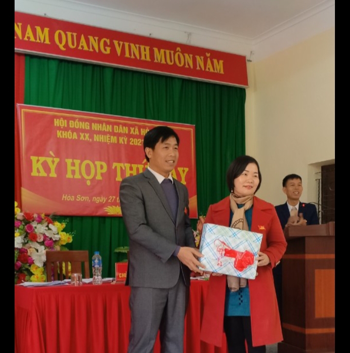 Đồng chí Hoàng Sỹ Nguyên, Phó bí thư Đảng ủy, Chủ tịch HĐND xã tặng quà thôi làm đại biểu HDND đối với bà Tạ Thị Tuyết Mai